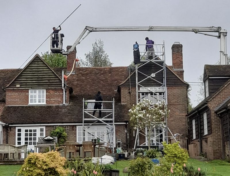The Moss Cleaners using cherry picker and scaffolding to clean roof safely and professionally in Mitcham, {{COUNTY}}